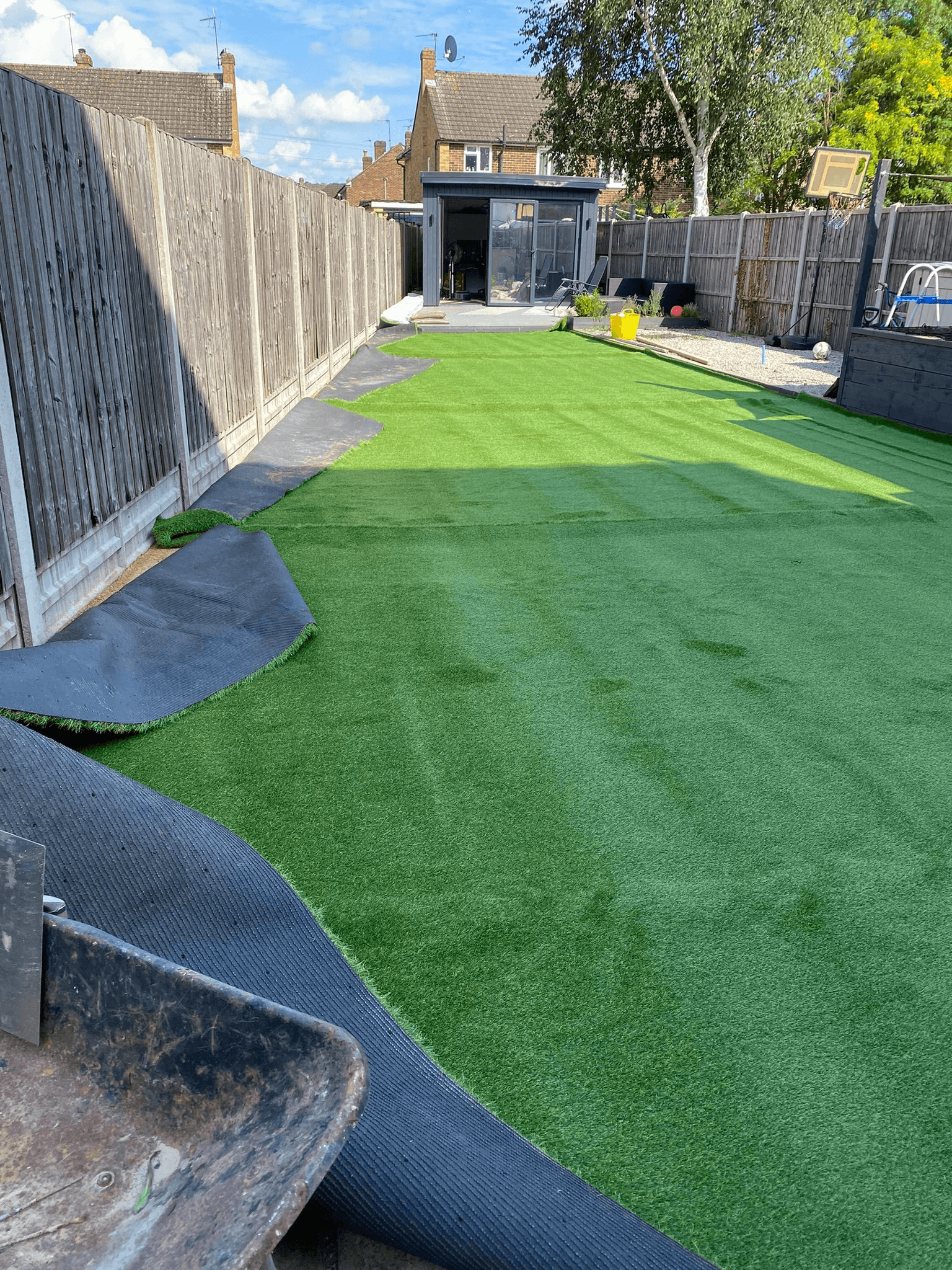 Artificial grass installation in progress in a garden